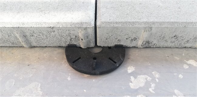 Płytki betonowe ułożone na czarnych podstawkach tarasowych