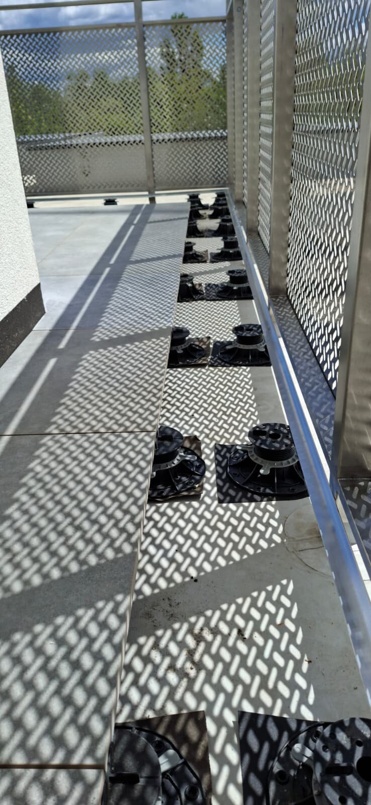Wsporniki regulowane pod płytami tarasowymi przy balustradzie