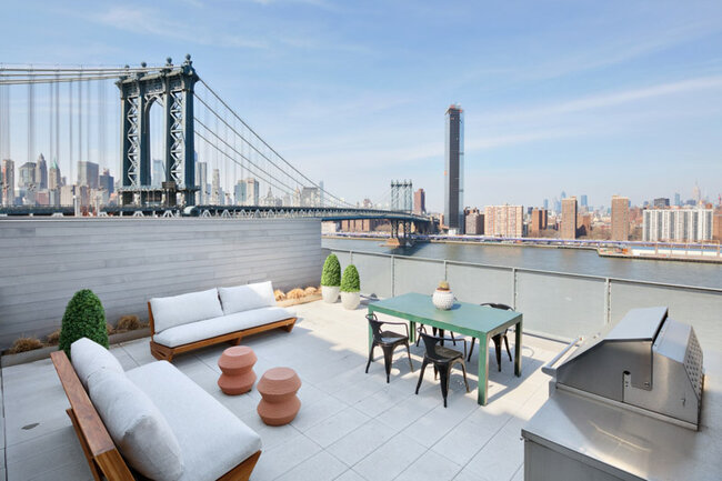 Luksusowy taras na dachu z meblami i widokiem na most Manhattan
