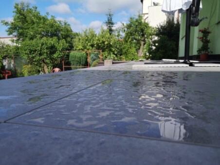 standing water puddling on a tiled outdoor patio surface