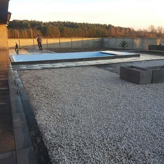 Pool deck tile installation combined with gravel drainage using pedestals.