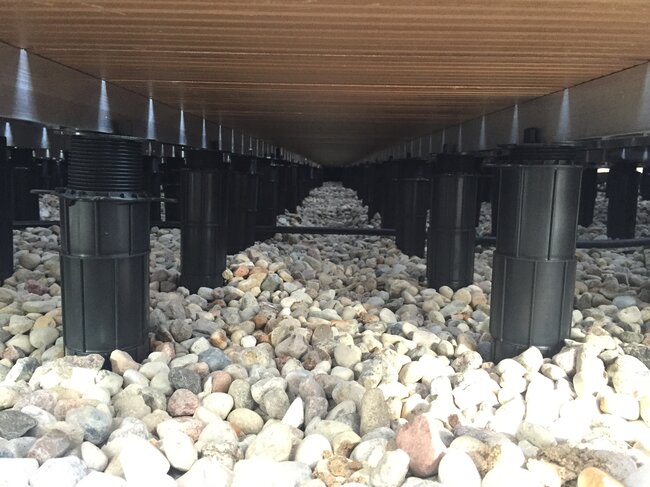 adjustable pedestal supports installed under wooden decking