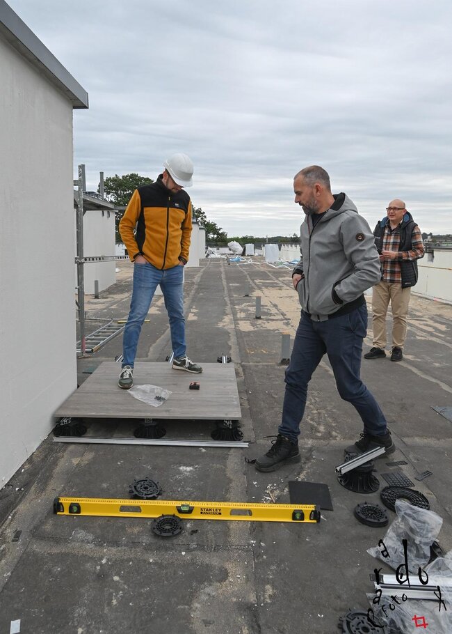 construction workers installing outdoor raised deck tiles on