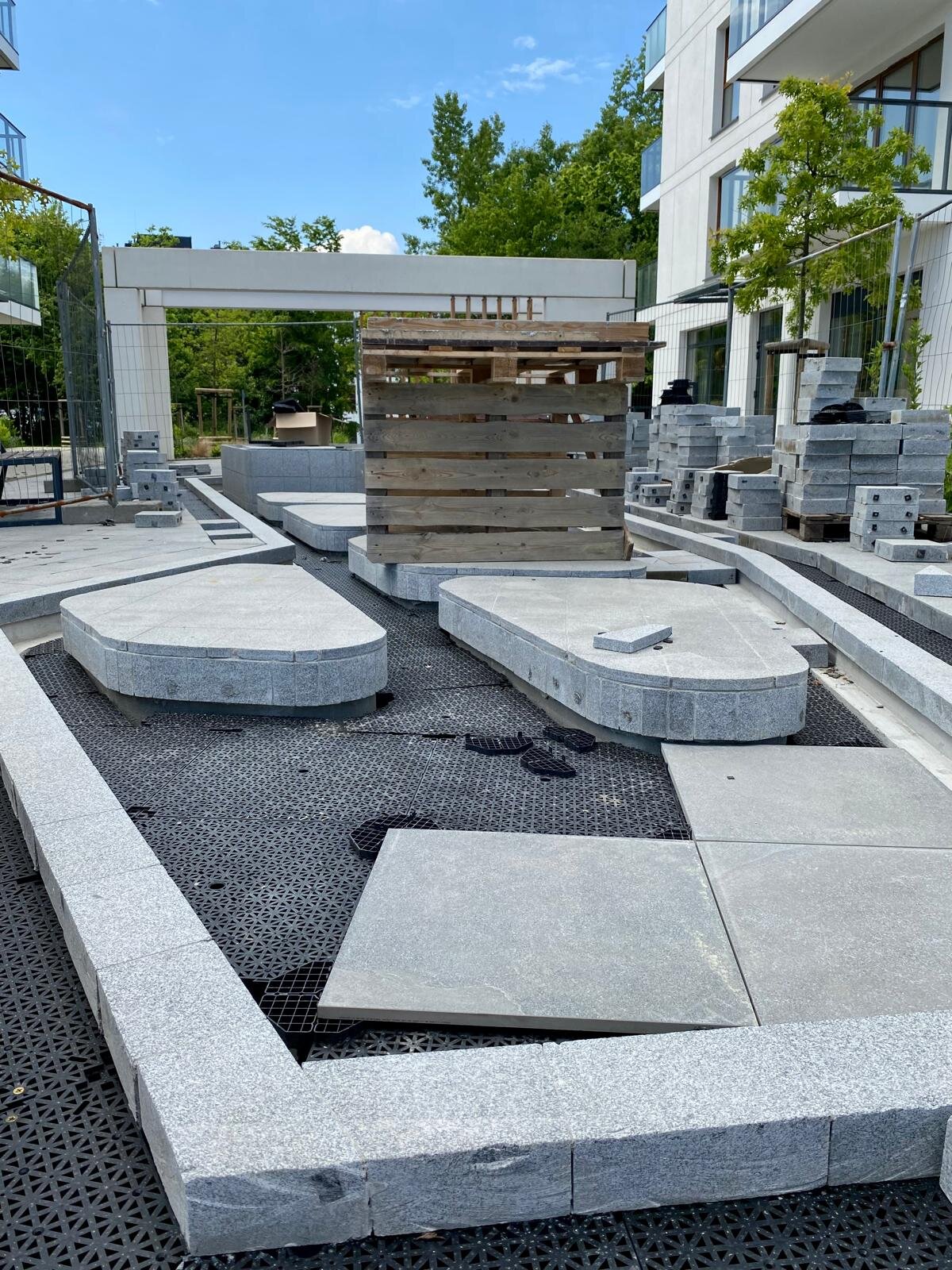 DeckSafe interlocking drainage subfloor panels being installed under stone pavers on an outdoor patio project.